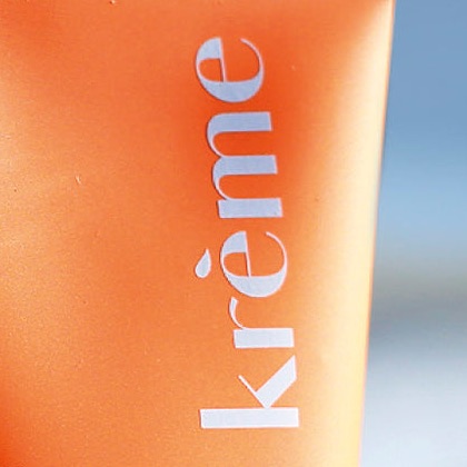 Tube de lait solaire Krème posé au bord de la mer