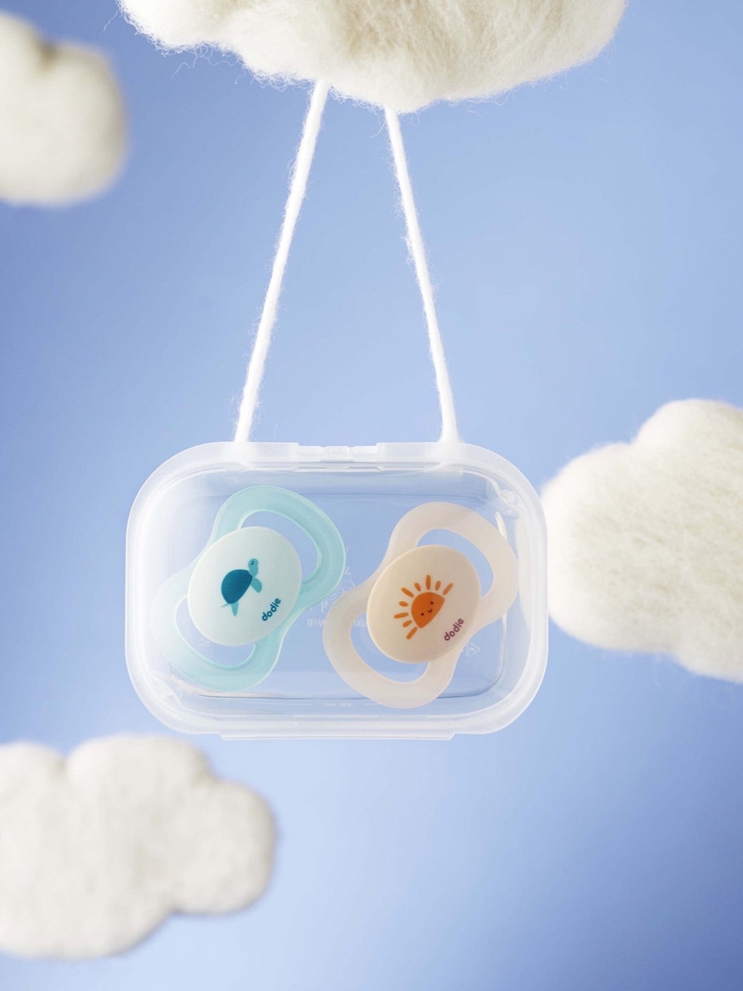 Dodie : deux sucettes dans leur boîte, entre des nuages