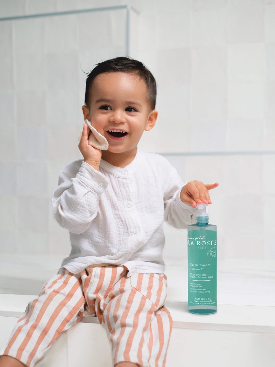 La Rosée : un petit garçon souriant à côté de l’eau nettoyante bébé à l’aloe vera bio