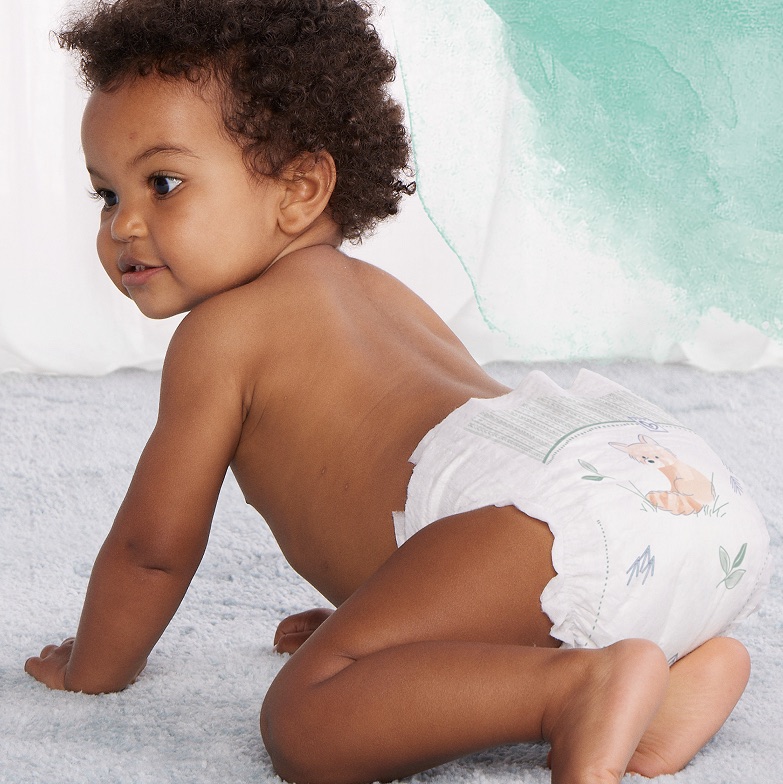 Un bébé à quatre pattes, en couche Pampers Harmonie